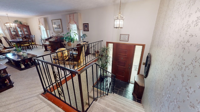 carpeted foyer entrance with a chandelier