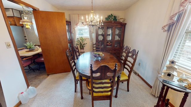 dining space featuring a chandelier and light carpet