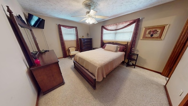 carpeted bedroom featuring ceiling fan and a textured ceiling