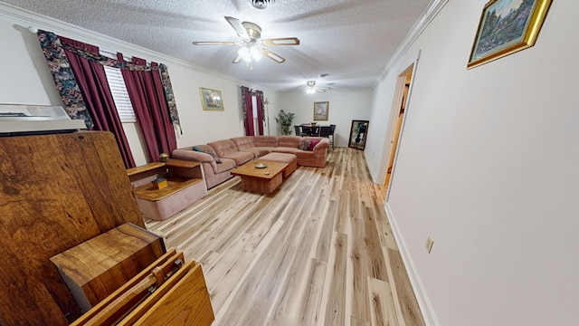 living room featuring ceiling fan, crown molding, light hardwood / wood-style floors, and a textured ceiling