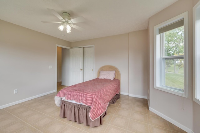 bedroom featuring ceiling fan, a closet, and multiple windows