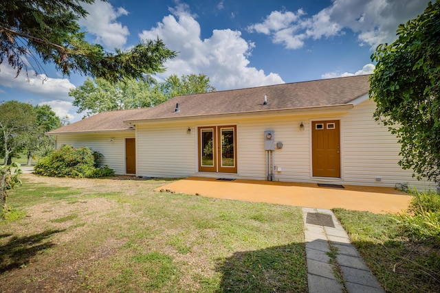 rear view of property with a patio and a lawn