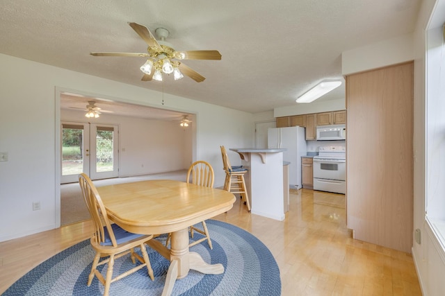 dining room with light hardwood / wood-style flooring and a textured ceiling