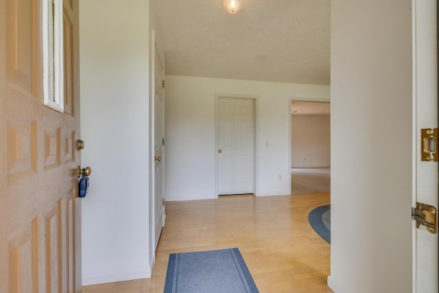 foyer entrance featuring a textured ceiling and light hardwood / wood-style floors