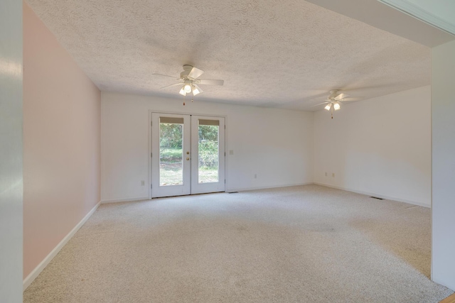 spare room with light carpet, a textured ceiling, ceiling fan, and french doors