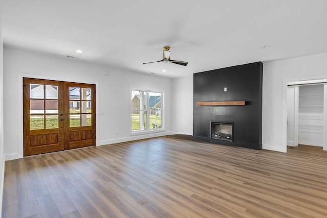 unfurnished living room with a fireplace, french doors, plenty of natural light, and ceiling fan