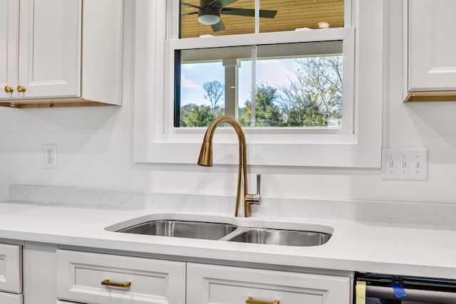 interior details featuring white cabinets, dishwashing machine, ceiling fan, and sink