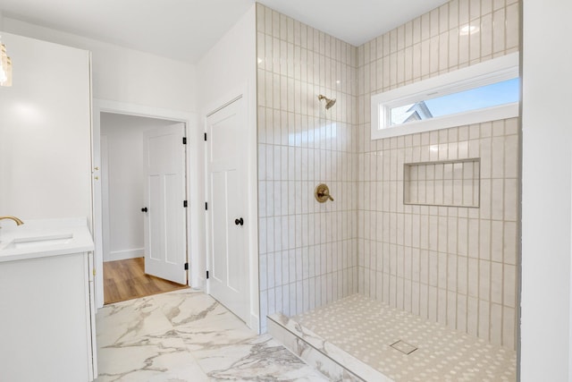 bathroom with vanity and tiled shower