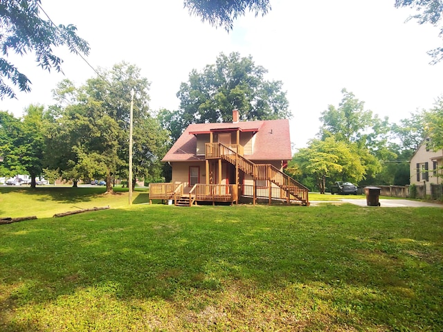 back of house with a wooden deck and a lawn