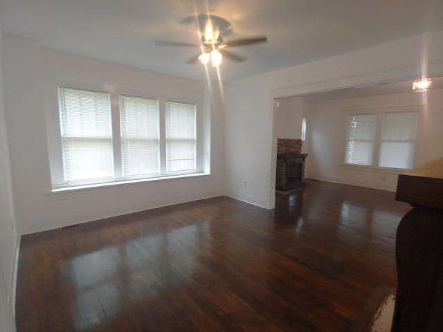 unfurnished living room with ceiling fan and dark wood-type flooring