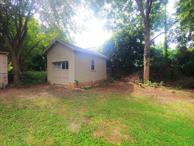 view of property exterior with a lawn, an outbuilding, and a garage