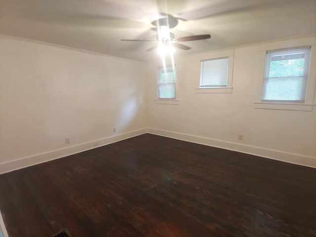 empty room featuring ceiling fan, dark hardwood / wood-style floors, and ornamental molding