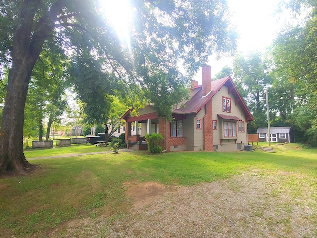 exterior space featuring a lawn, cooling unit, and a storage unit