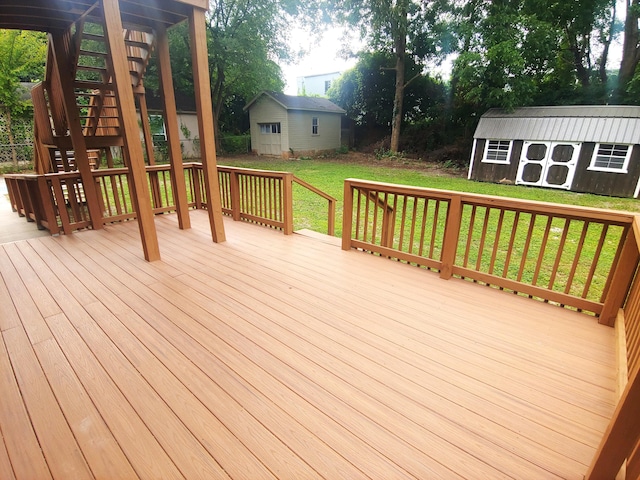 wooden terrace featuring a yard and a storage shed