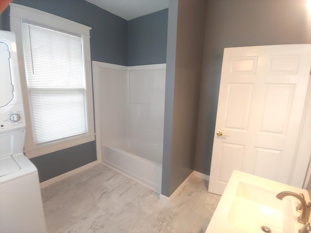 bathroom featuring stacked washer / drying machine and sink