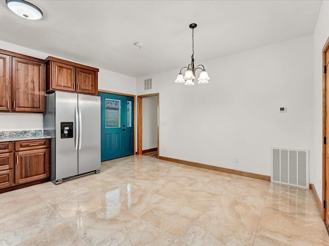 107 Straight Creek Dock Rd, New Tazewell, TN 37825 - kitchen with stainless steel fridge, a chandelier, pendant lighting, brown cabinetry, and light stone countertops