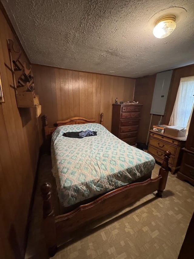 bedroom with wood walls and a textured ceiling