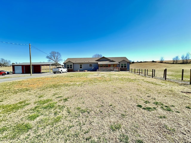 view of yard featuring a garage, fence, and an outdoor structure