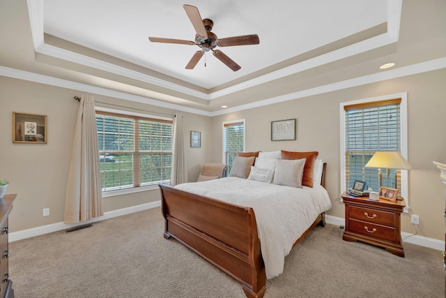 bedroom with a raised ceiling, ceiling fan, light colored carpet, and ornamental molding