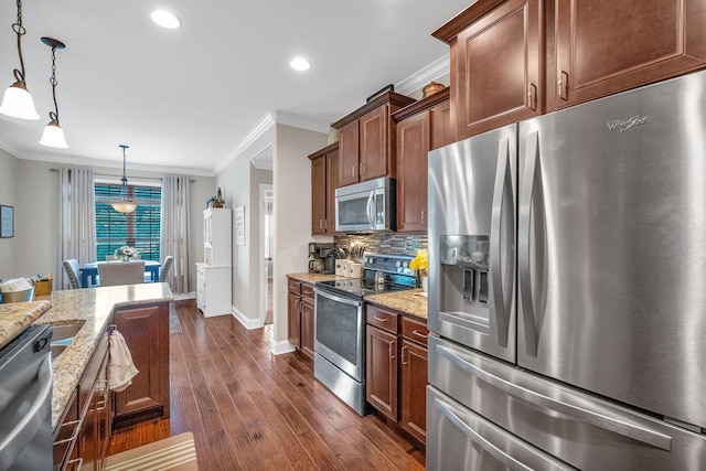 kitchen featuring hanging light fixtures, stainless steel appliances, light stone counters, decorative backsplash, and ornamental molding