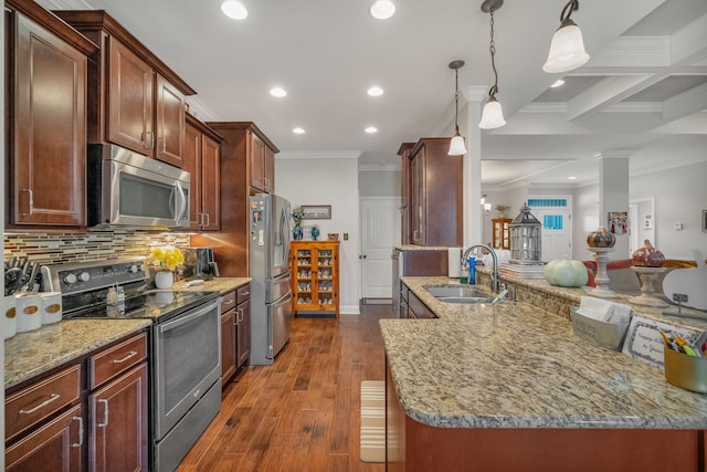 kitchen featuring sink, tasteful backsplash, beamed ceiling, pendant lighting, and appliances with stainless steel finishes