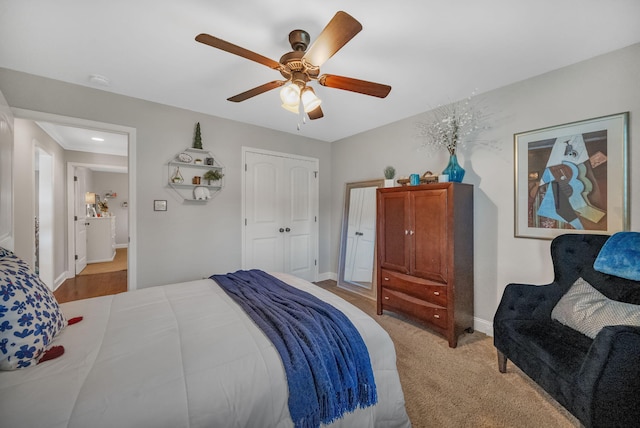 bedroom featuring ceiling fan, a closet, and light colored carpet