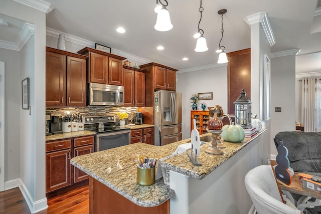 kitchen featuring a breakfast bar, appliances with stainless steel finishes, dark hardwood / wood-style floors, and pendant lighting