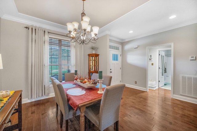 dining room featuring a chandelier, dark hardwood / wood-style flooring, and crown molding