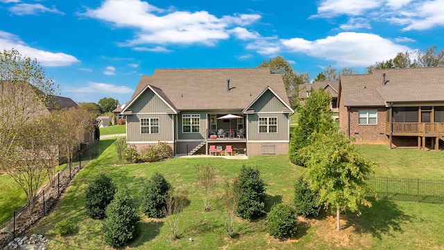 rear view of property featuring a wooden deck and a yard