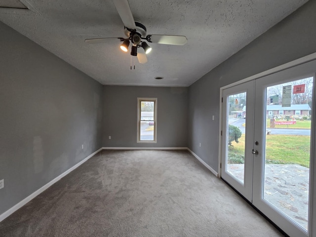 empty room featuring ceiling fan, french doors, light colored carpet, and a textured ceiling