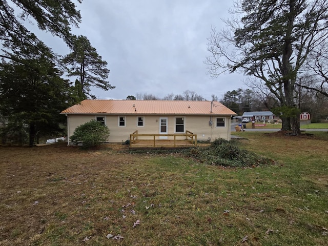 rear view of property featuring a lawn and a wooden deck