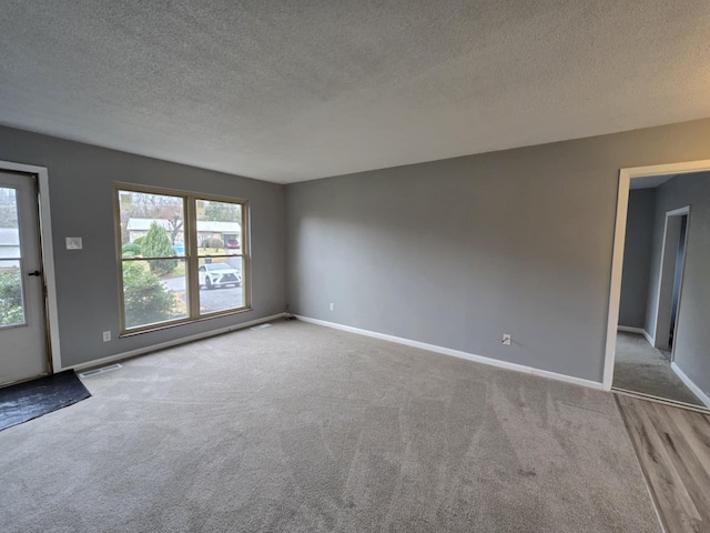 carpeted spare room featuring a textured ceiling