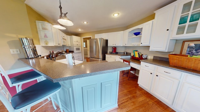 4119 Azalea Ct, Morristown, TN 37814 - kitchen with open shelves, white appliances, a peninsula, light wood finished floors, and a breakfast bar