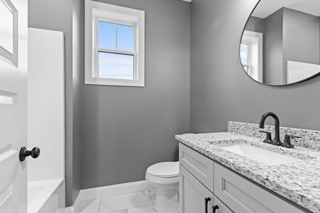 bathroom with a tub, vanity, and toilet