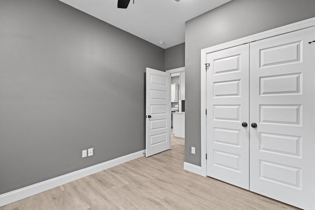 unfurnished bedroom with light hardwood / wood-style flooring, a closet, and ceiling fan