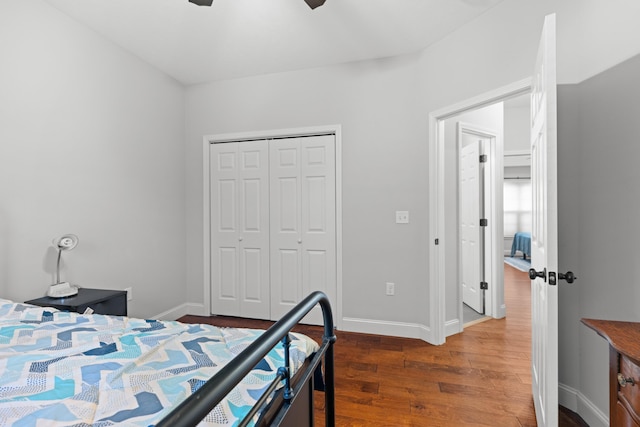 bedroom with ceiling fan, a closet, and dark wood-type flooring