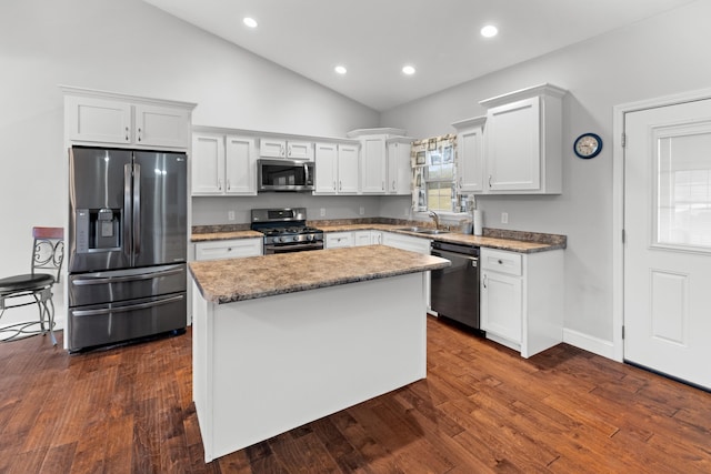 kitchen with stainless steel appliances, a kitchen island, white cabinetry, and sink