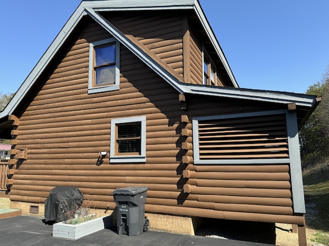 view of home's exterior with crawl space and log siding