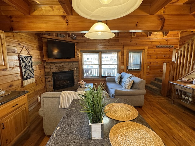 living area with wooden walls, a fireplace, stairway, and wood finished floors