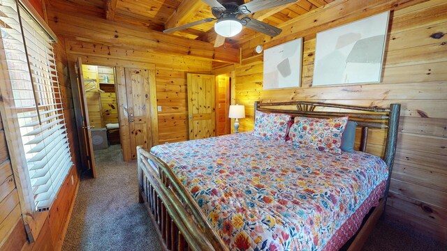 carpeted bedroom with wood ceiling, beamed ceiling, and wood walls