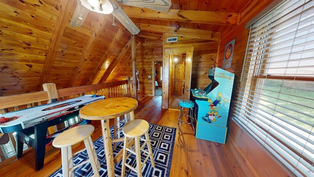 playroom featuring visible vents, wood-type flooring, wooden walls, wooden ceiling, and lofted ceiling with beams