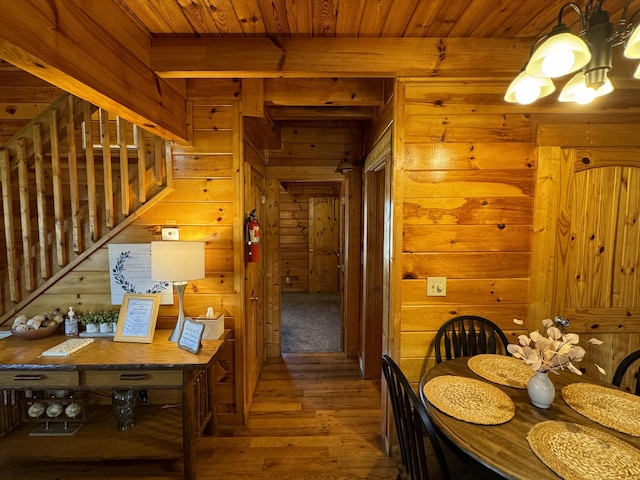 interior space with wood-type flooring, stairway, wood ceiling, wooden walls, and beamed ceiling