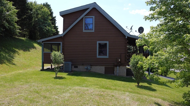 view of side of home with log siding, a yard, and central AC