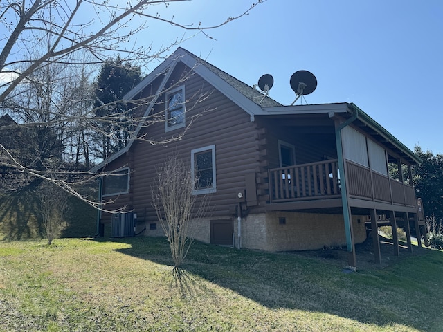 view of side of home with central air condition unit, log siding, and a yard