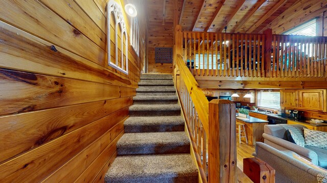 stairway featuring wooden walls, wood ceiling, and lofted ceiling