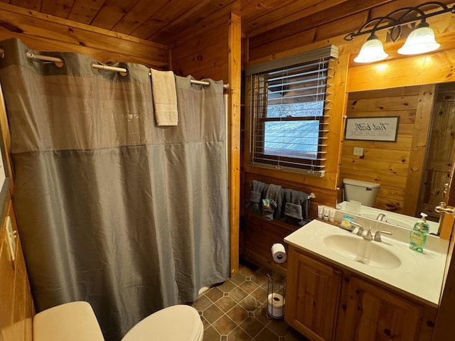 bathroom with toilet, wood walls, wood ceiling, and vanity