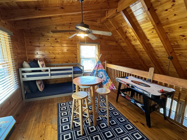 bedroom with vaulted ceiling with beams, hardwood / wood-style floors, wooden ceiling, and wooden walls