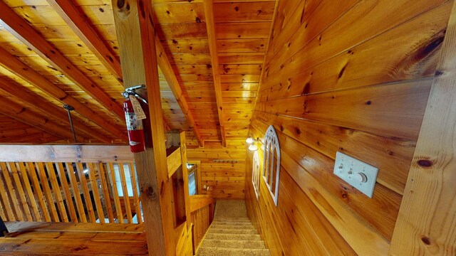 bathroom featuring wooden walls, a healthy amount of sunlight, vaulted ceiling with beams, and visible vents