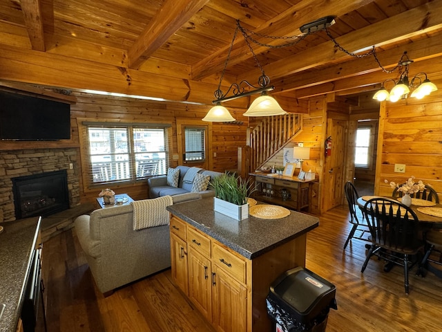 interior space featuring wood walls, wood ceiling, a fireplace, and dark wood-style floors