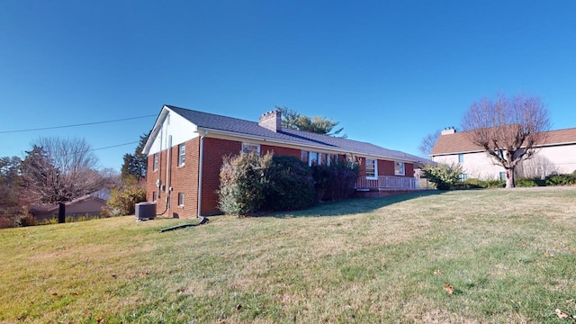 view of side of home with central AC and a lawn